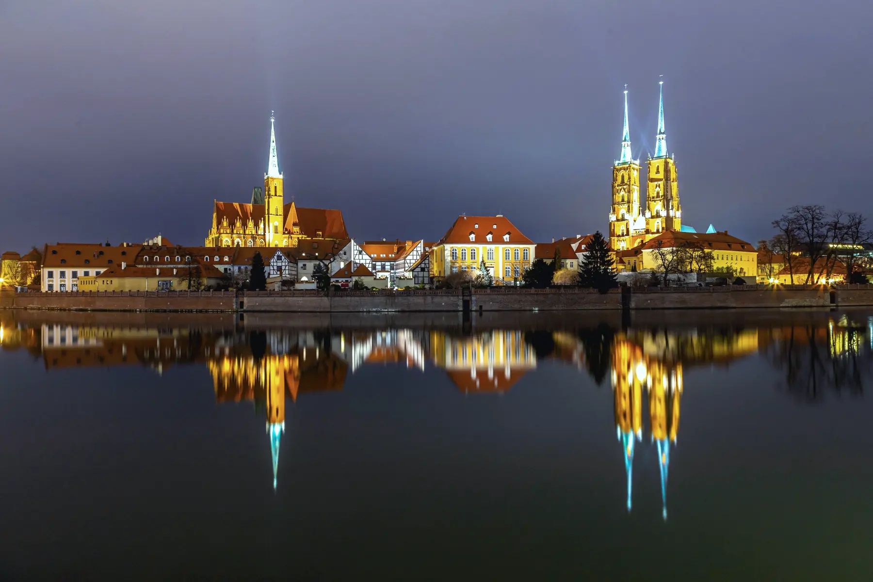 Ostrów Tumski we Wrocławiu nocą, odbity w Odrze